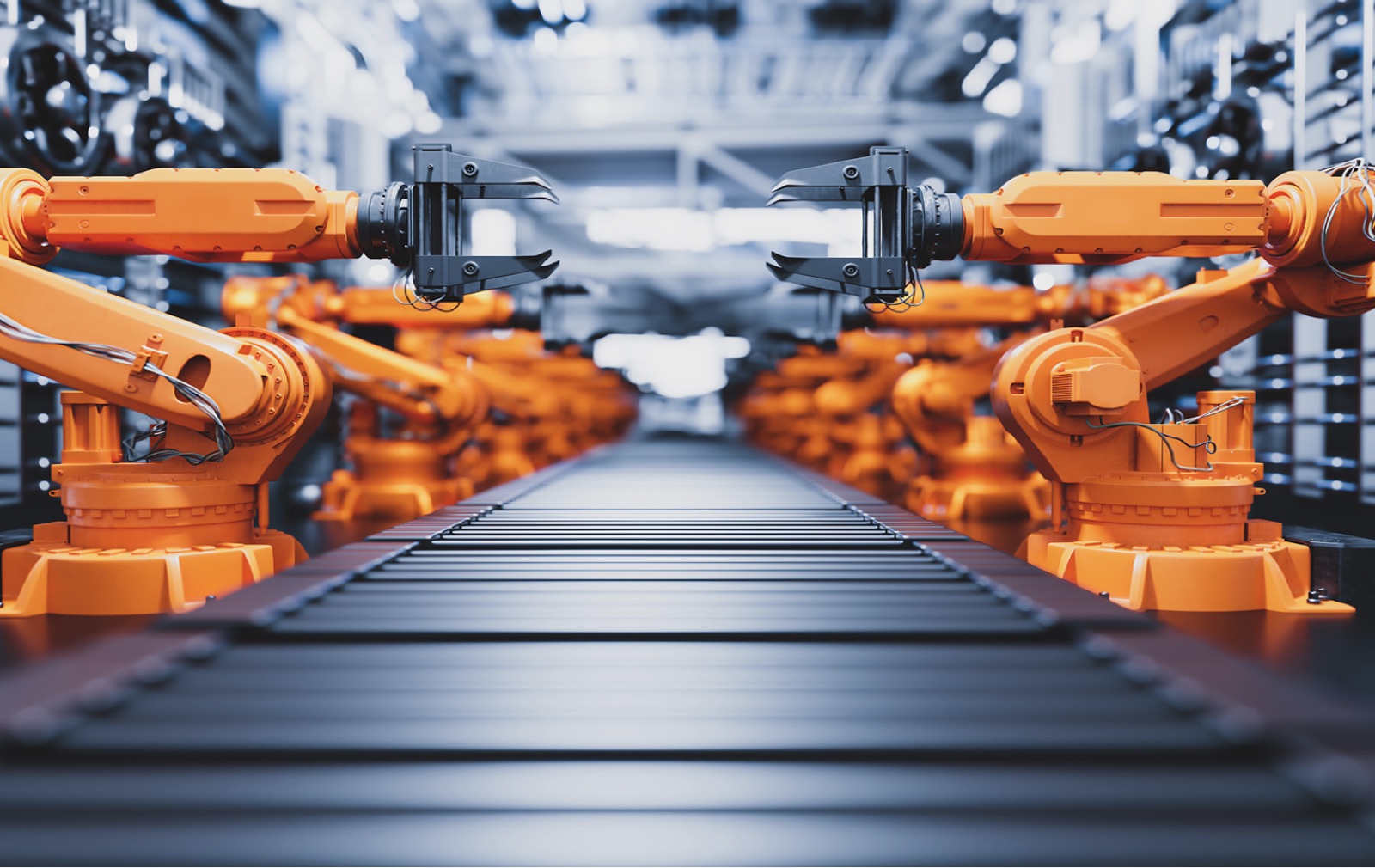 Orange robotic arms on an automated factory line